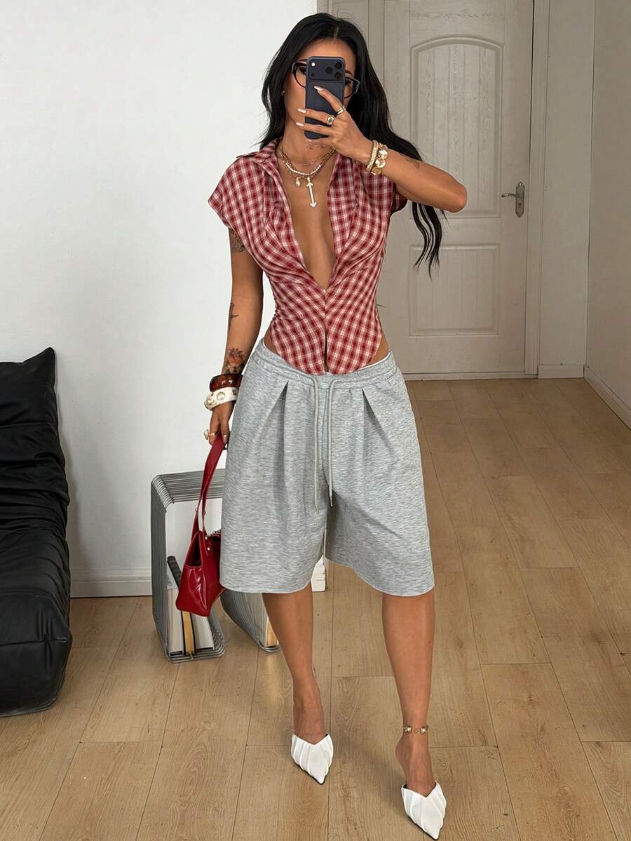 Women's plaid short sleeve shirt featuring a lapel collar and backless design in woven fabric.