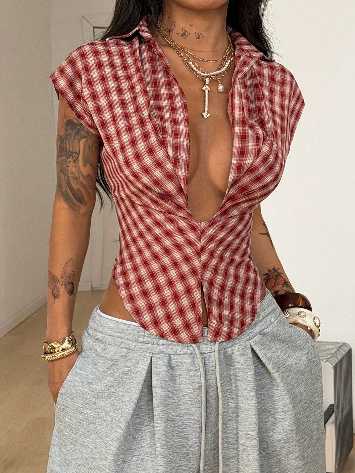 Women's plaid short sleeve shirt featuring a lapel collar and backless design in woven fabric.