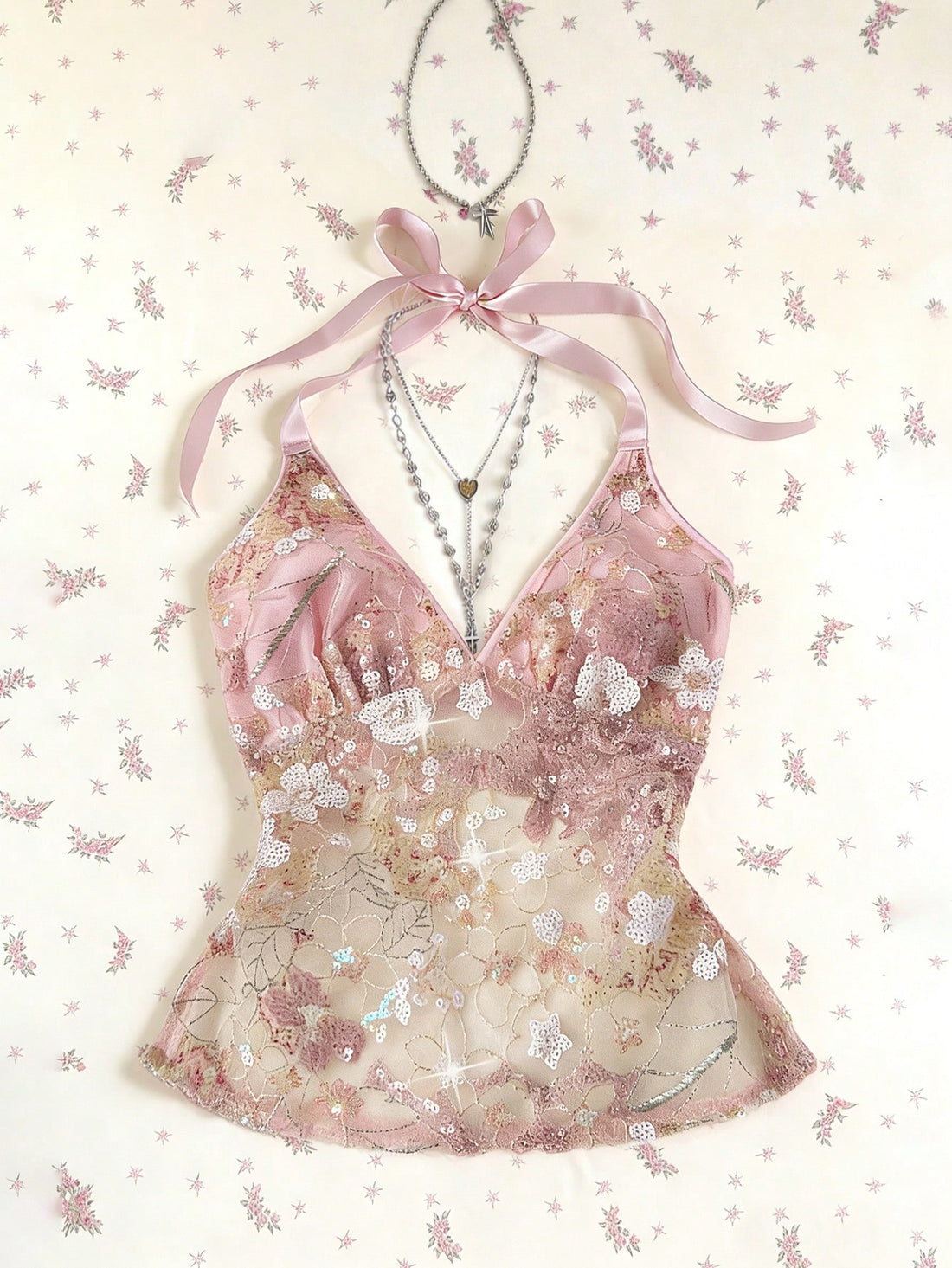 Pink sheer lace tie-up halter crop top featuring floral sequin patchwork, deep V-neck, and backless tie-back design.