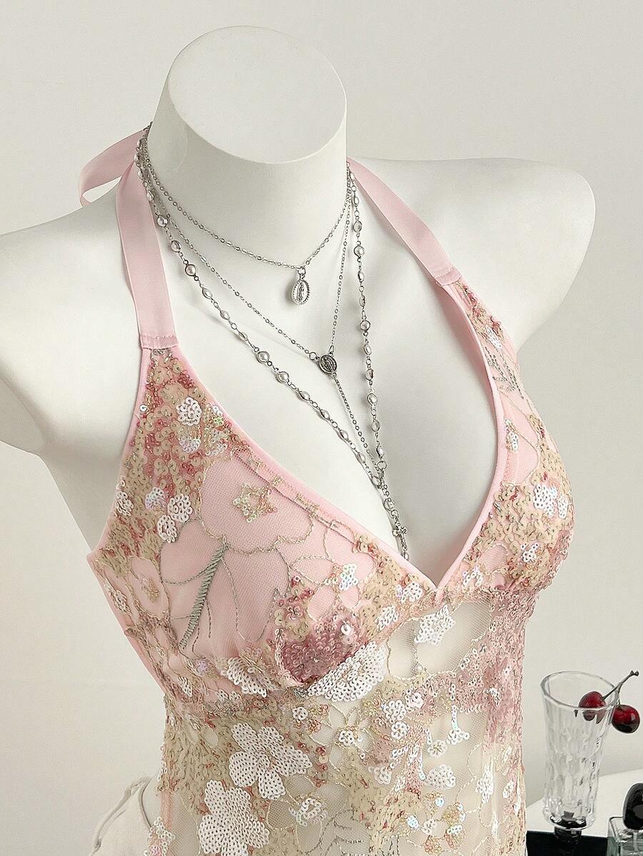 Pink sheer lace tie-up halter crop top featuring floral sequin patchwork, deep V-neck, and backless tie-back design.