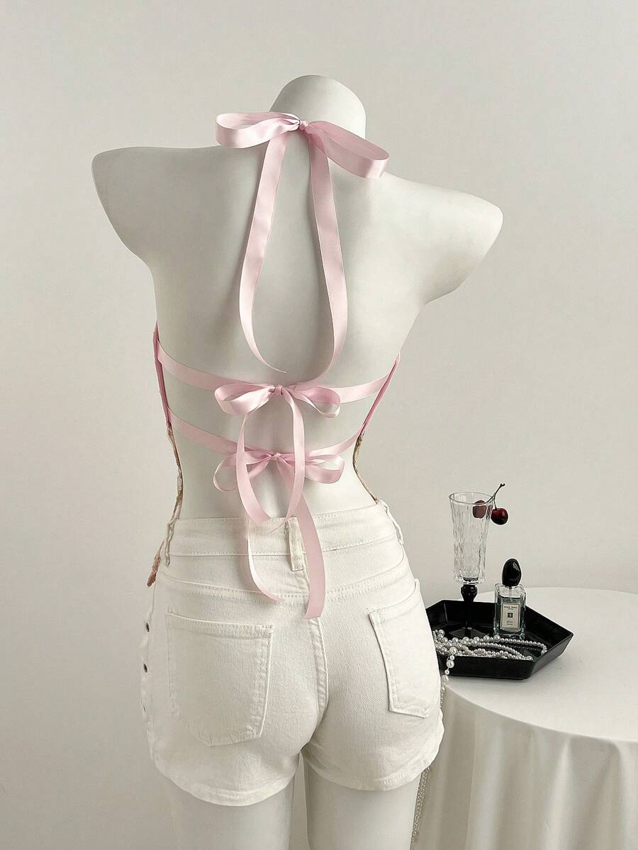 Pink sheer lace tie-up halter crop top featuring floral sequin patchwork, deep V-neck, and backless tie-back design.