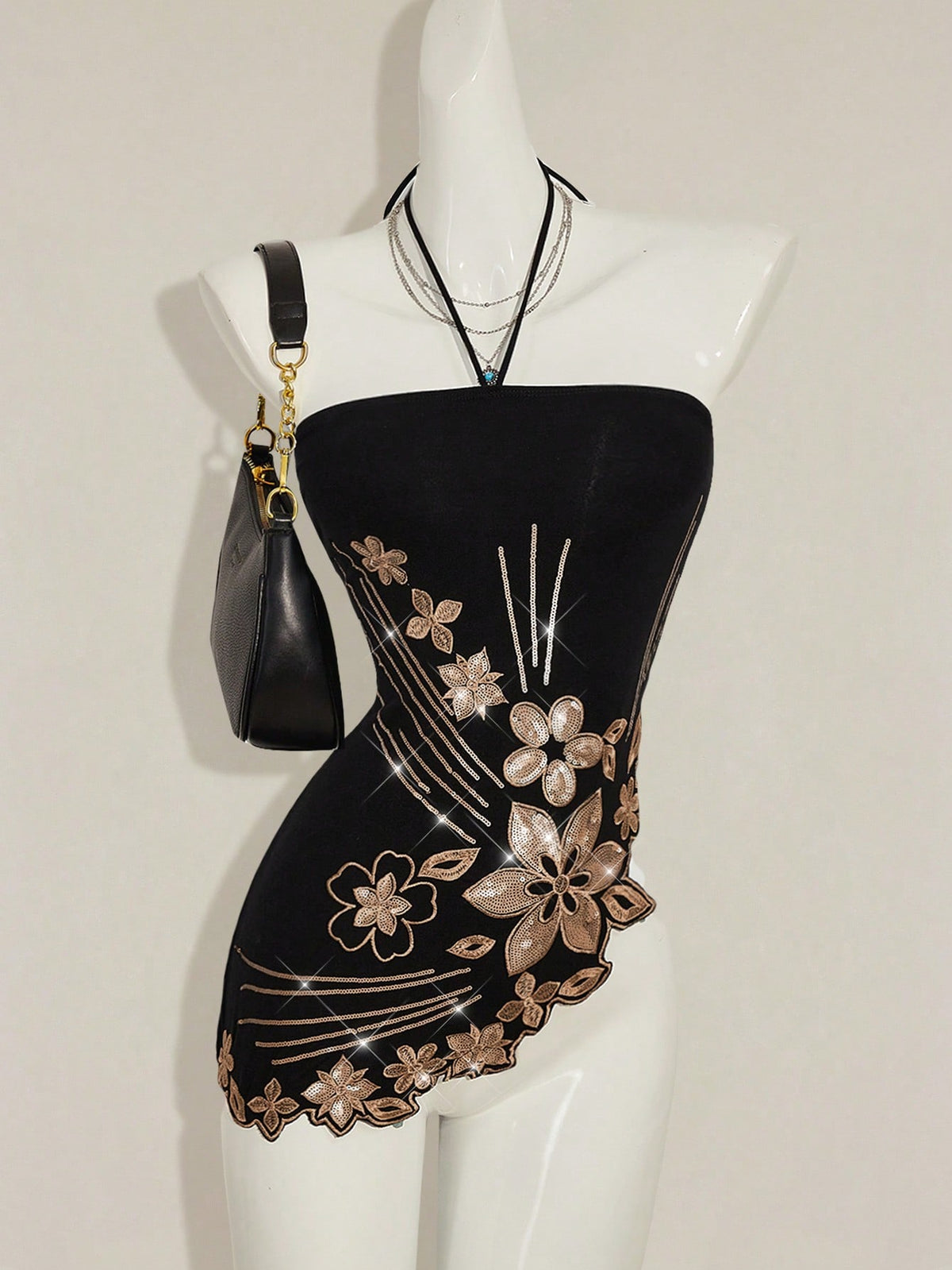 Women's black asymmetrical knitted halter top featuring a slim fit and colorblock pattern