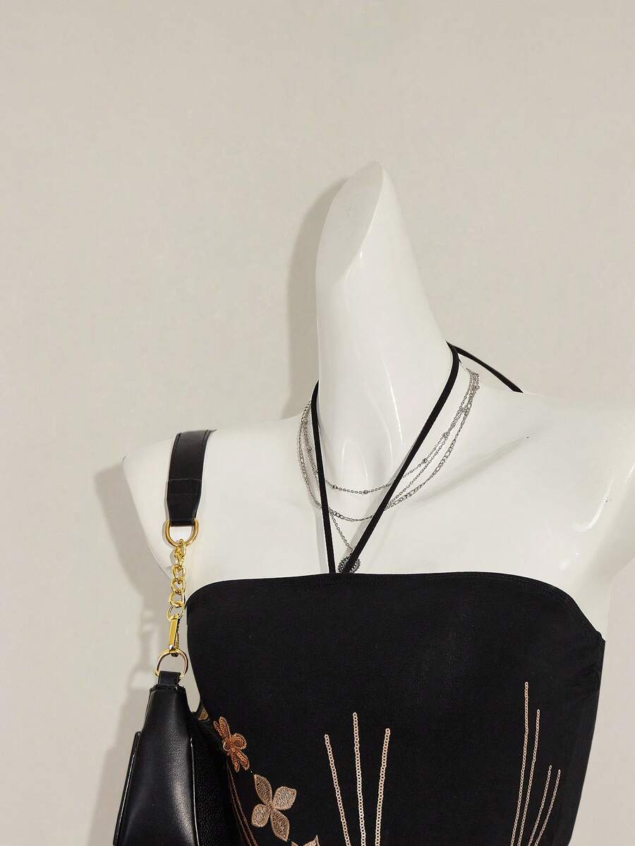 Women's black asymmetrical knitted halter top featuring a slim fit and colorblock pattern