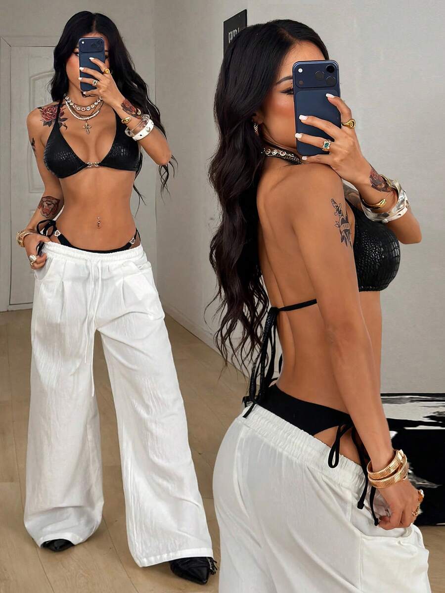 Women's slim fit halter crop top featuring a backless cut with knot and rhinestone accents.
