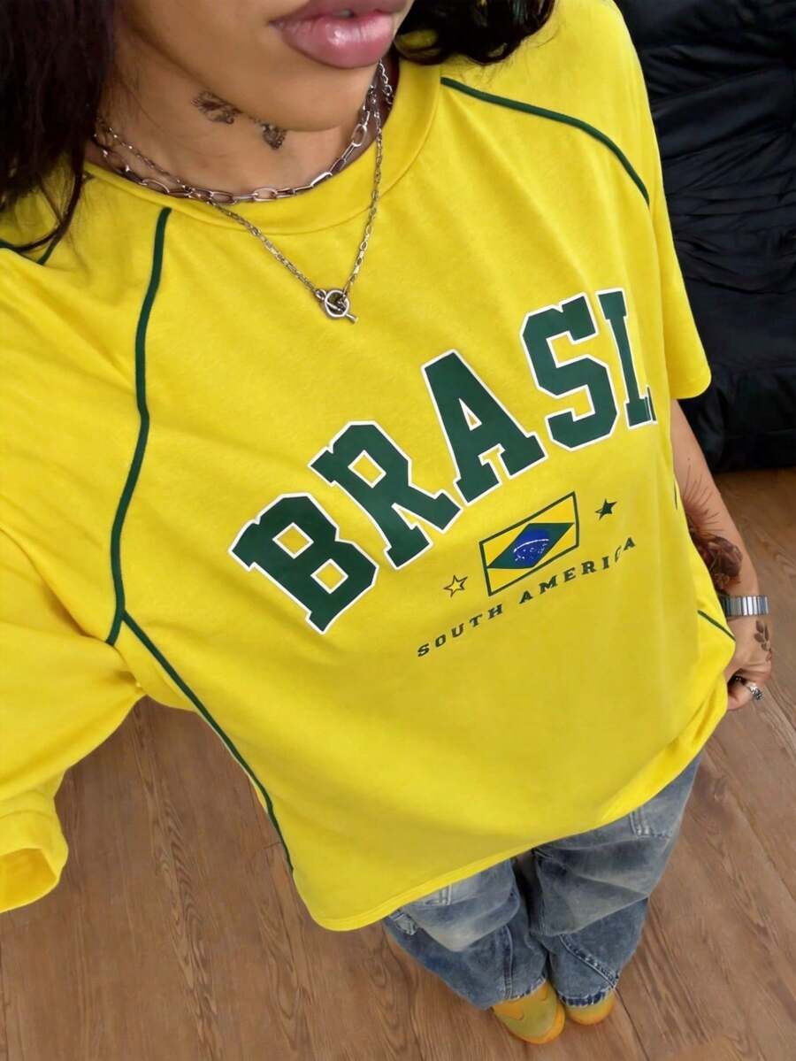 Yellow oversized graphic t-shirt featuring Brazil letter print on the front with contrast raglan sleeves and side stripe detailing.