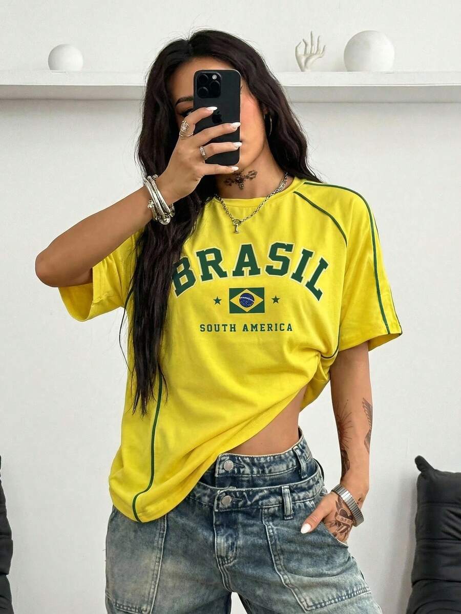 Yellow oversized graphic t-shirt featuring Brazil letter print on the front with contrast raglan sleeves and side stripe detailing.
