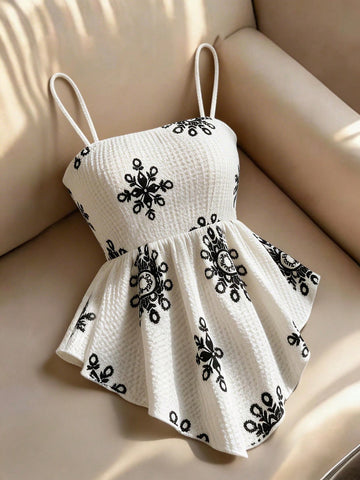 Women's floral snowflake print camisole top featuring spaghetti straps, slim fit, and an asymmetrical hem in navy blue knit fabric.
