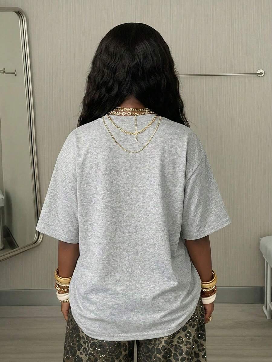 Women's oversized graphic crew neck t-shirt made of 100% white cotton knitted fabric with drop shoulder half sleeves.