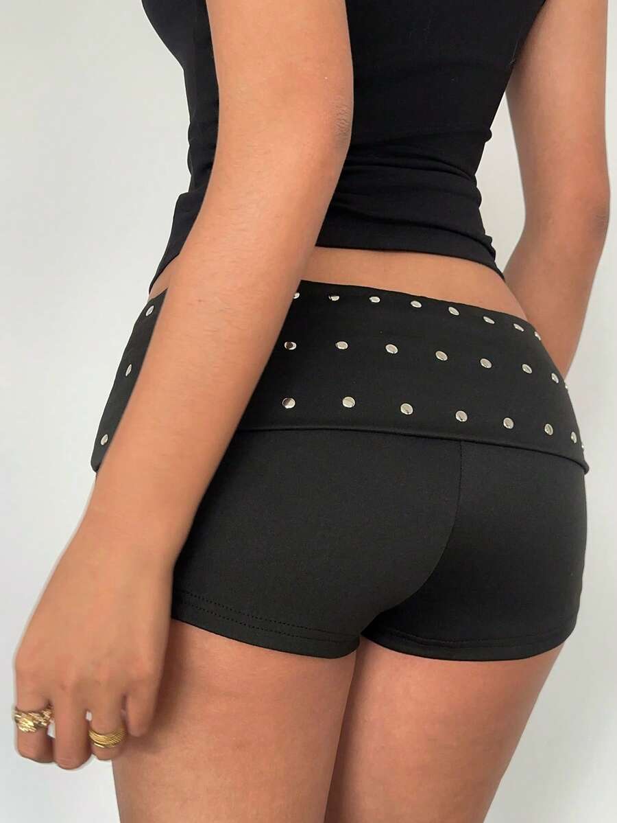 Women's ultra low waist mini shorts with rhinestone studded detailing, skinny fit, and mini length.