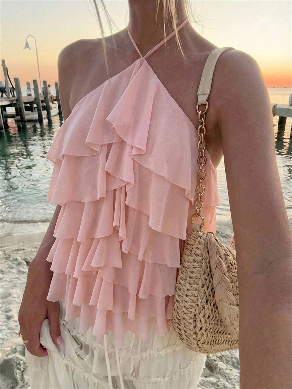 Women's sleeveless halter neck top featuring tiered ruffle layers, a backless cut, and an asymmetrical hem.
