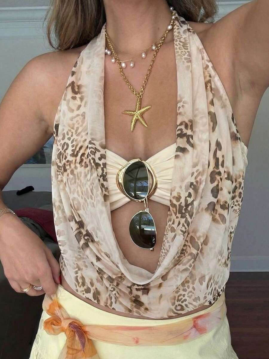Brown and white polka dot semi-sheer halter camisole top with a plunging neckline, backless design, draped front, and metallic studded embellishments.