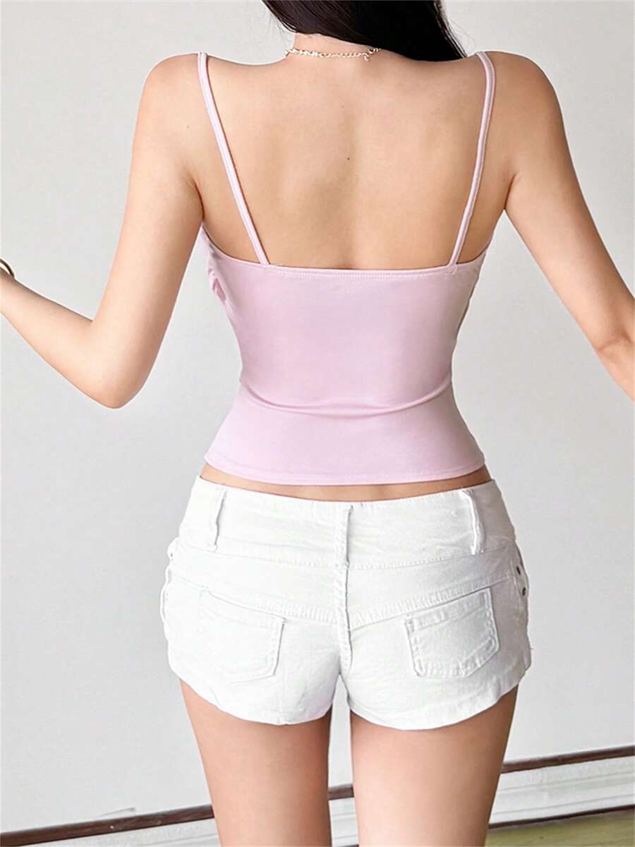 Pink women's boned crop cami top with adjustable spaghetti straps and an asymmetrical hem.