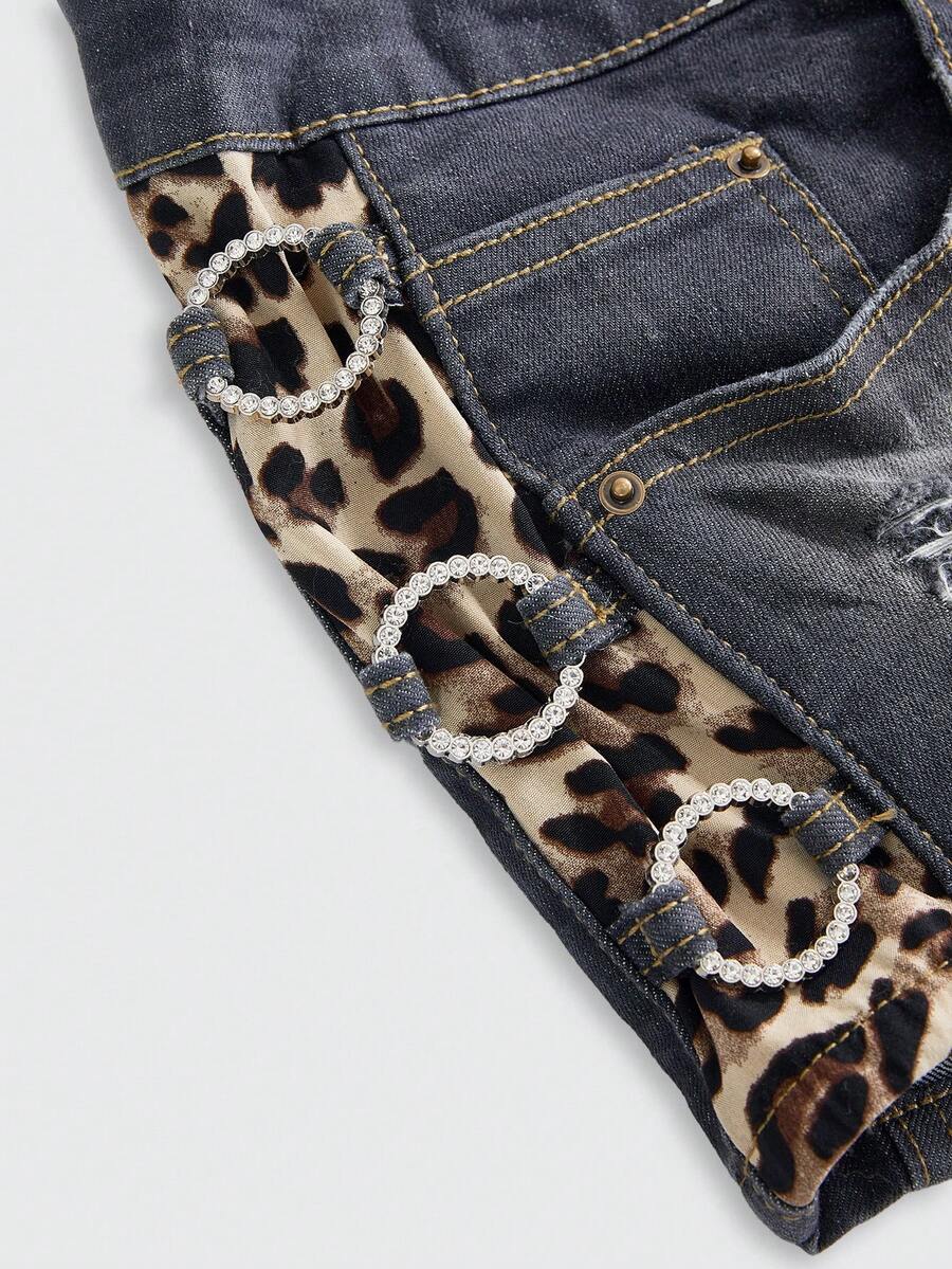 Women's ultra low waist vintage Y2K leopard print skinny mini shorts featuring ripped details, button, and zipper fly.