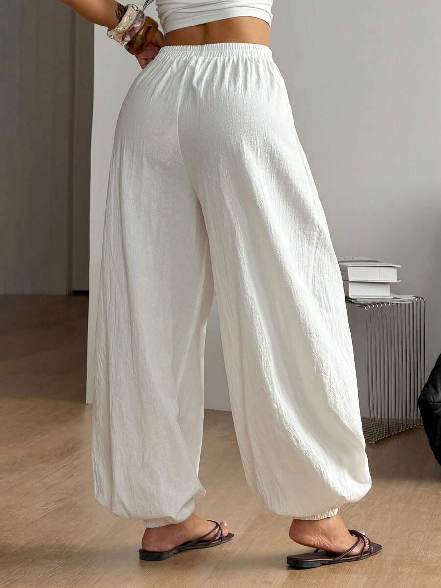 Women's loose-fit black bloomer pants made of 100% cotton featuring an elastic waistband and side pockets.