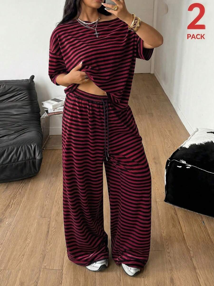 Women's casual two-piece outfit featuring a loose short-sleeve asymmetrical neck t-shirt and matching long wide leg pants with pockets.