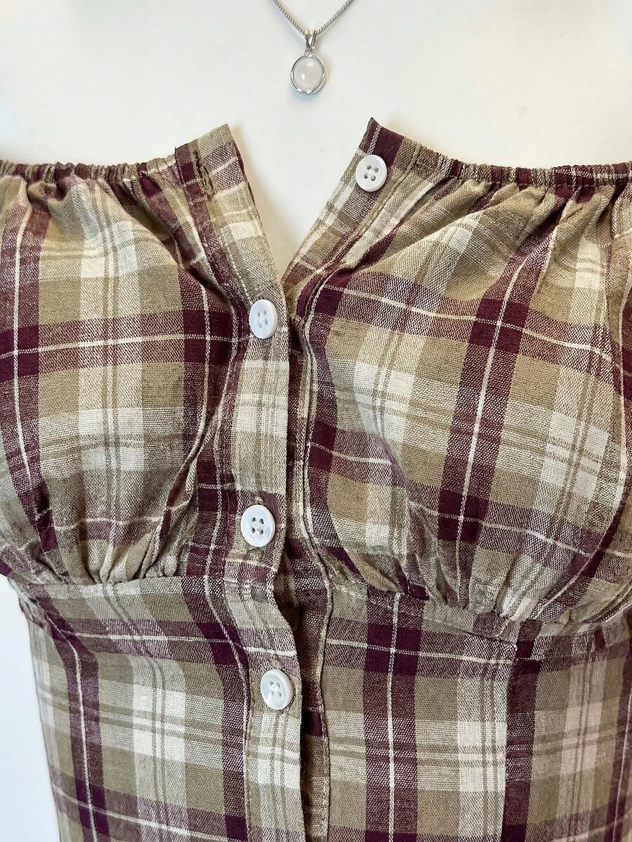 Women's army green plaid off-the-shoulder shirt with short puff sleeves, front button closure, flared hem, and lace-up grommet eyelet details.