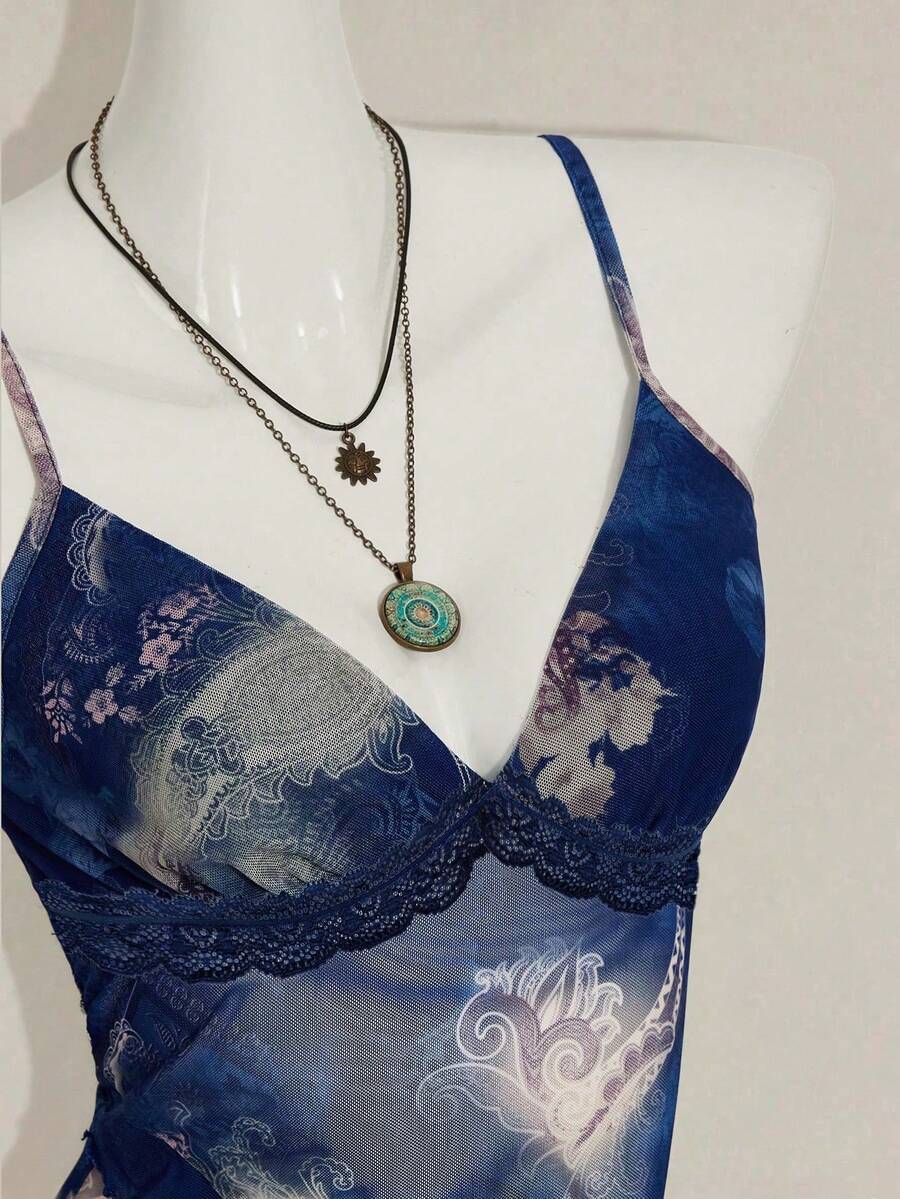 Women's graphic print camisole top featuring thin spaghetti straps, a backless cut, and an asymmetrical hem.
