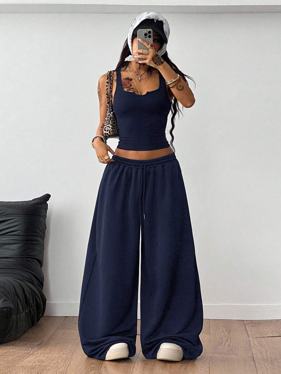 Women's two-piece casual outfit featuring a slim-fit camisole tank top with ruffle trim and button front paired with high-waisted wide leg pants.
