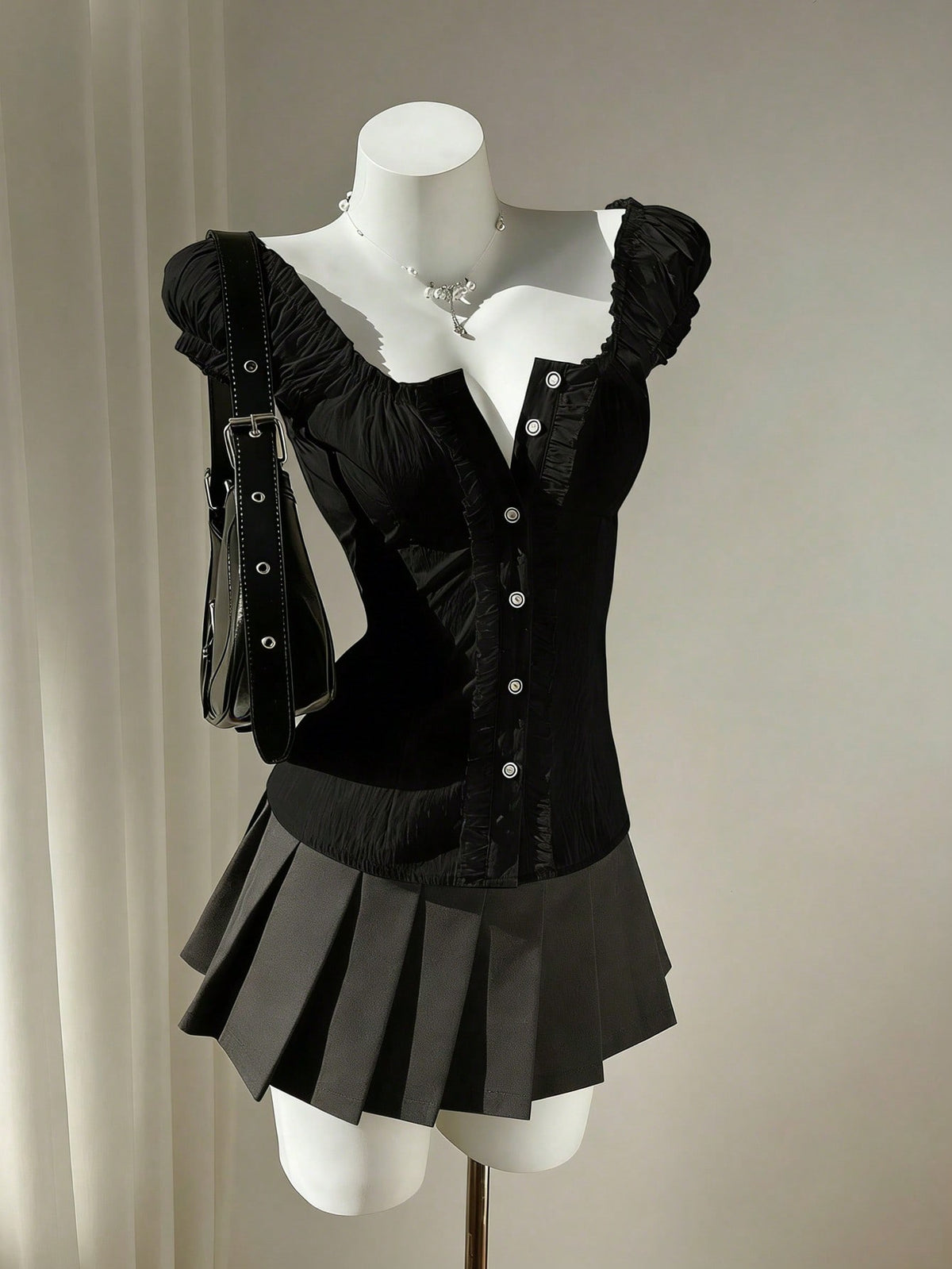Women's black off-shoulder cap sleeve blouse with ruffled detailing and a tie-back design.