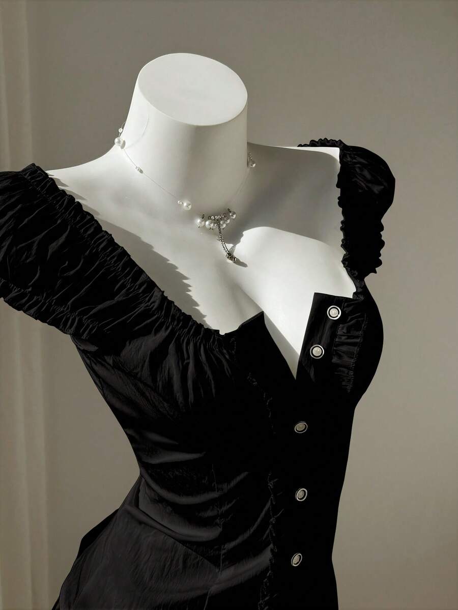 Women's black off-shoulder cap sleeve blouse with ruffled detailing and a tie-back design.
