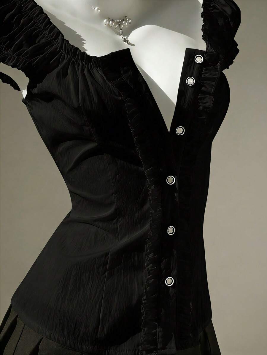 Women's black off-shoulder cap sleeve blouse with ruffled detailing and a tie-back design.