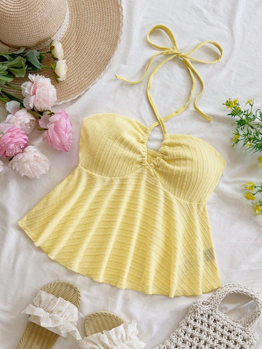 Women's textured V-neck halter tank top with backless knot detail, ruffle hem, and flared silhouette for casual beach and vacation wear.