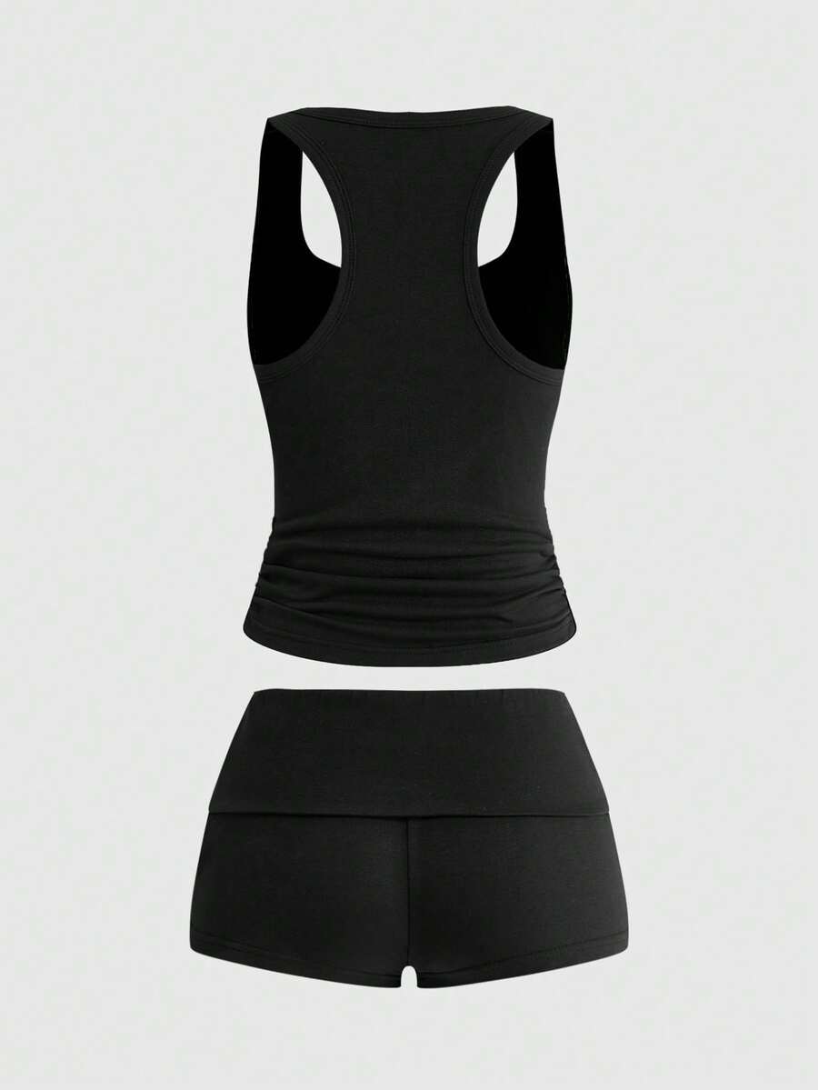 Punk-inspired two-piece set with a fitted scoop neck slogan tank top featuring cross and rhinestone details paired with ultra low waist mini shorts.