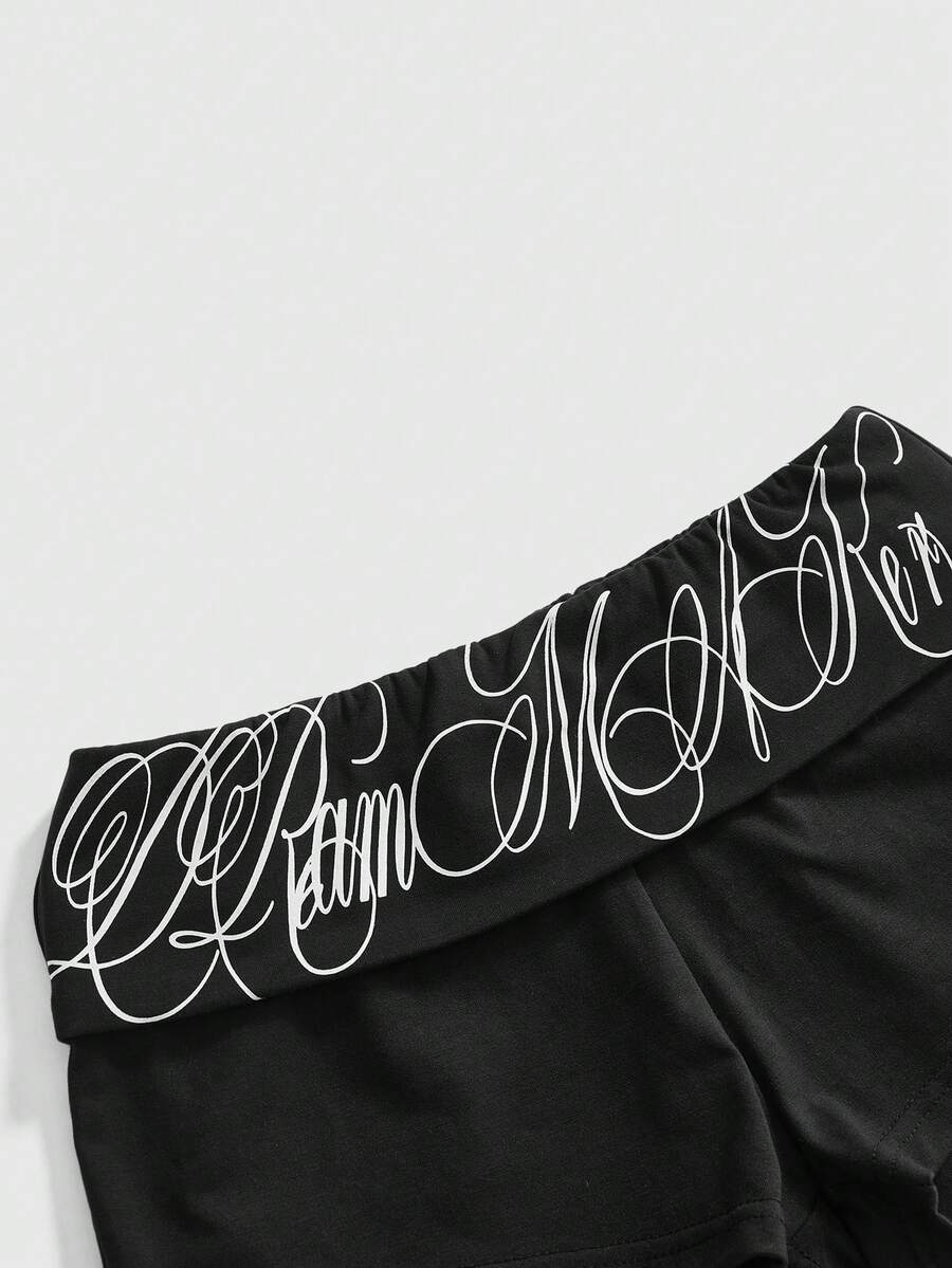Punk-inspired two-piece set with a fitted scoop neck slogan tank top featuring cross and rhinestone details paired with ultra low waist mini shorts.