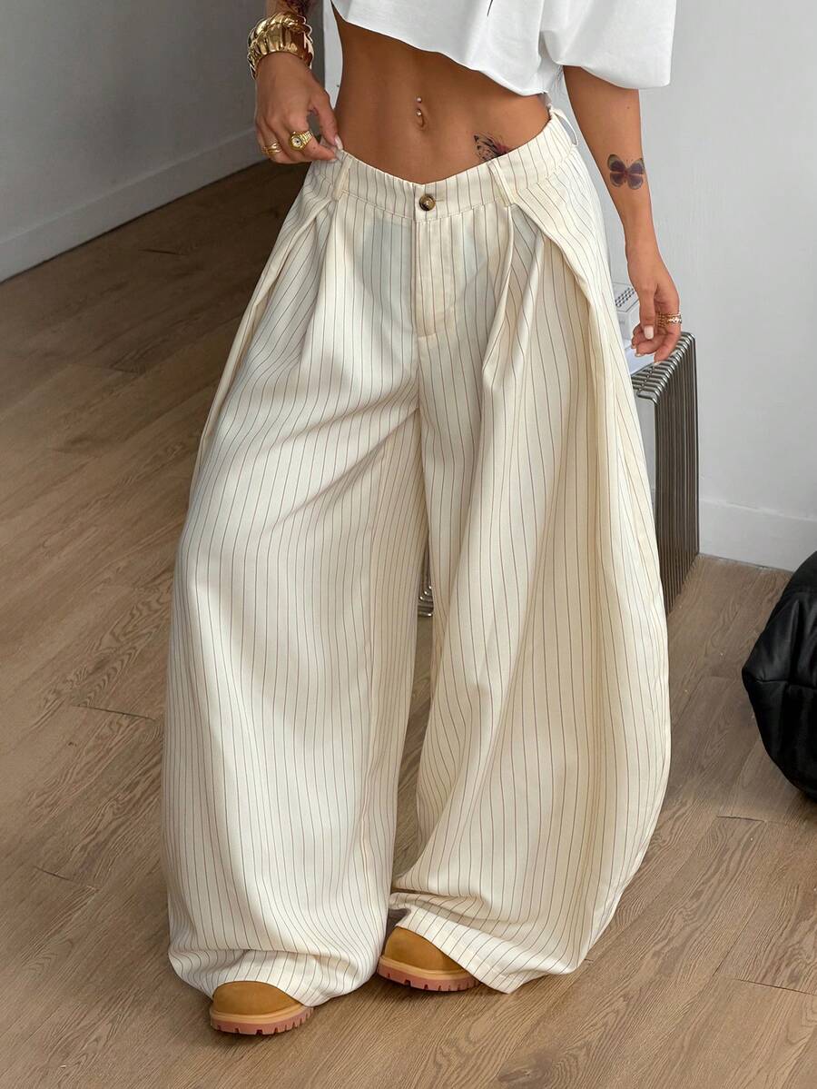 Women's brown striped wide leg pants with a low waist, curved hem, and loose casual fit in woven fabric.