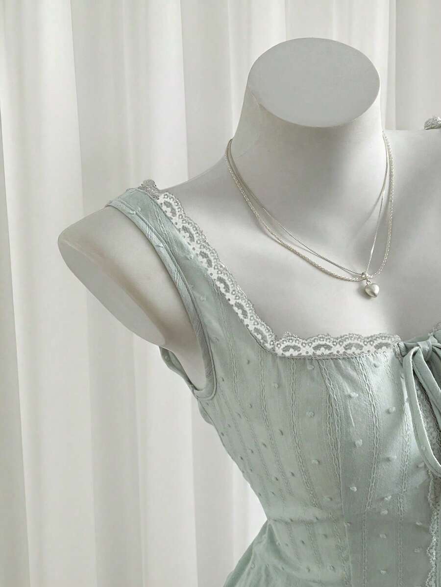 Women's 100% cotton sleeveless camisole top featuring a square neckline, wide straps, lace-up knot detail, and an asymmetrical hem.