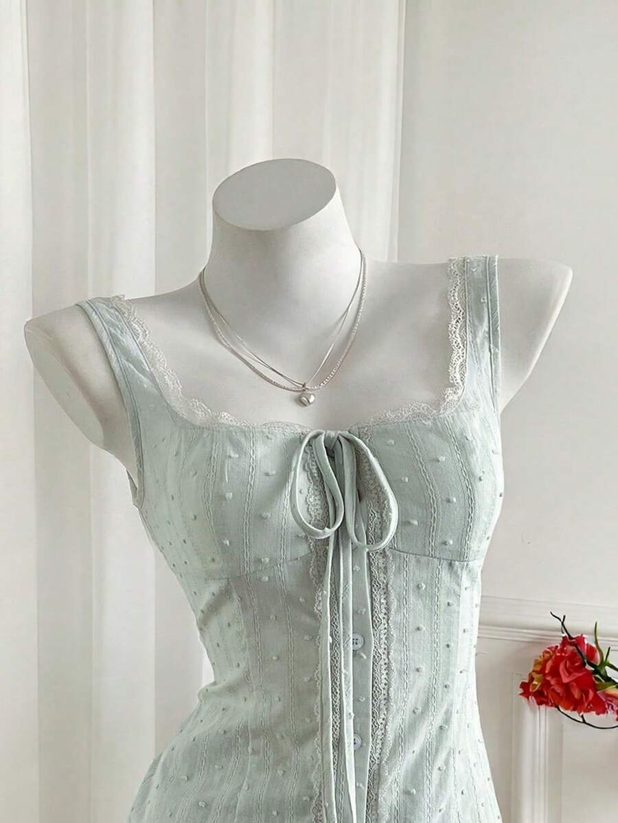 Women's 100% cotton sleeveless camisole top featuring a square neckline, wide straps, lace-up knot detail, and an asymmetrical hem.