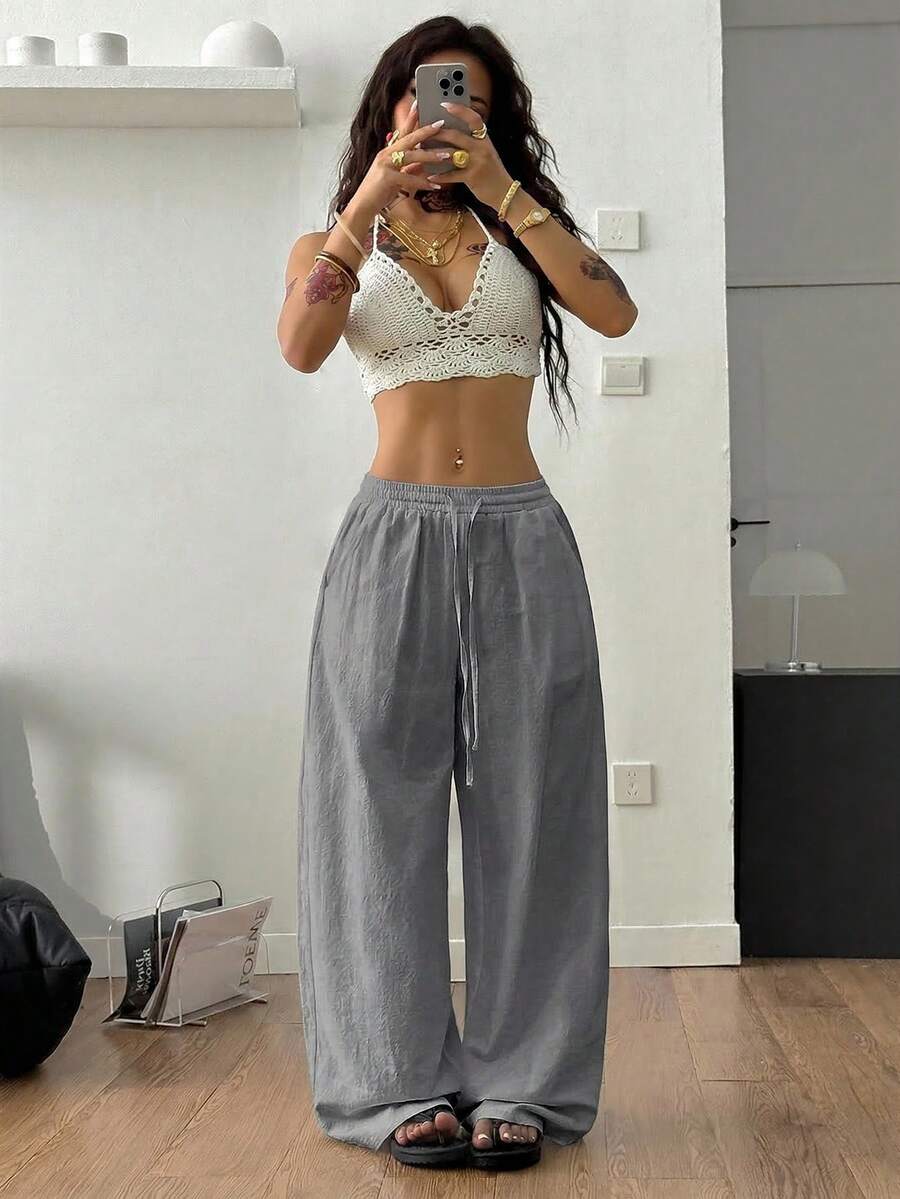 Women's black and white striped wide leg pants featuring an adjustable drawstring waist and side pockets.
