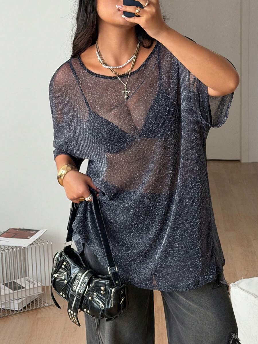 Women's plus size black sheer mesh top featuring a loose fit, round neck, and drop shoulder half sleeves.