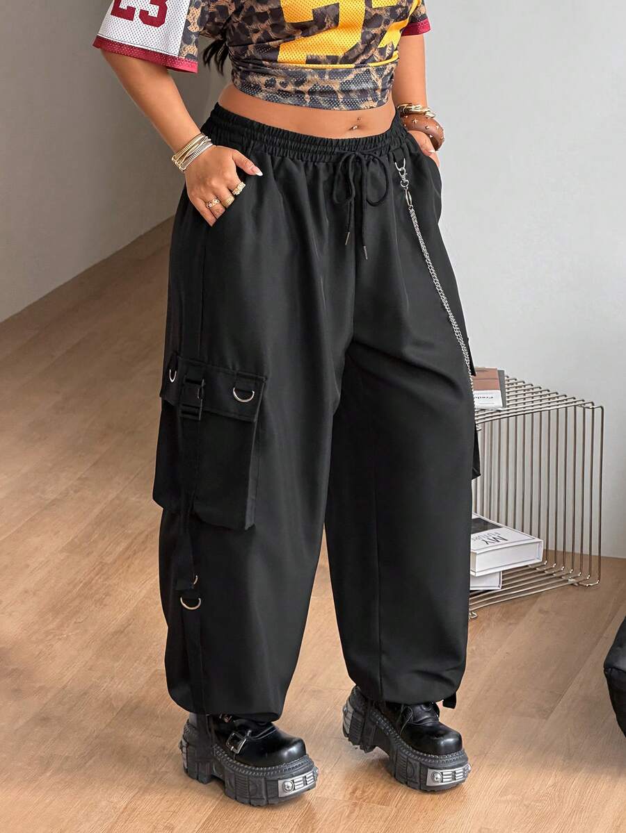 Black plus size cargo pants with drawstring waist and chain accent on loose-fit woven fabric.