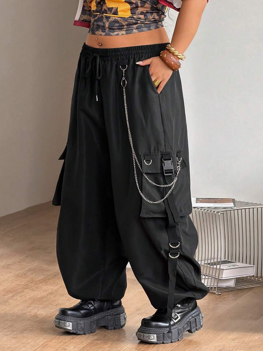 Black plus size cargo pants with drawstring waist and chain accent on loose-fit woven fabric.