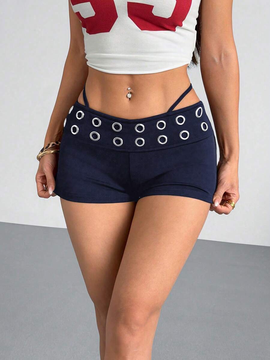 Women's casual track shorts with elastic waist, low-rise mini length, colorblock graphic pattern, and cut-out studded grommet eyelet details.