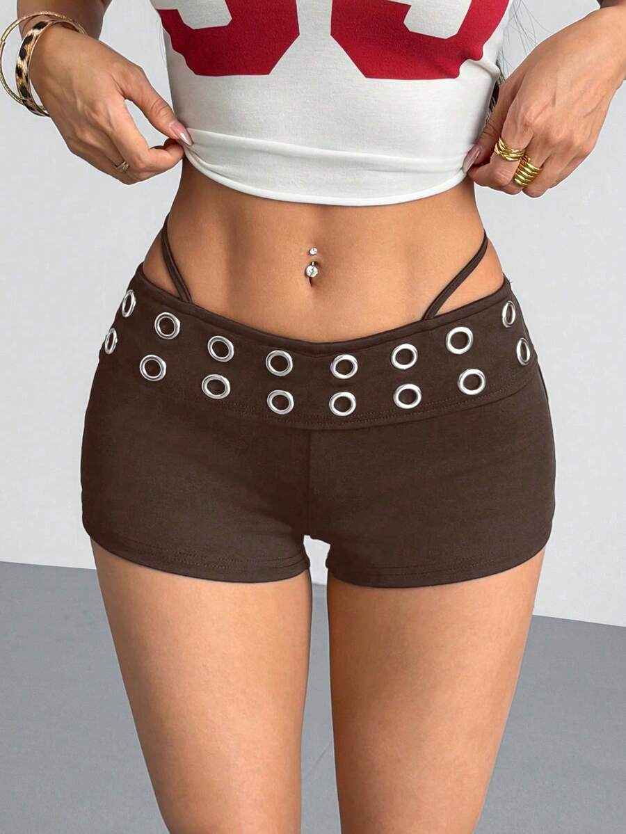 Women's casual track shorts with elastic waist, low-rise mini length, colorblock graphic pattern, and cut-out studded grommet eyelet details.