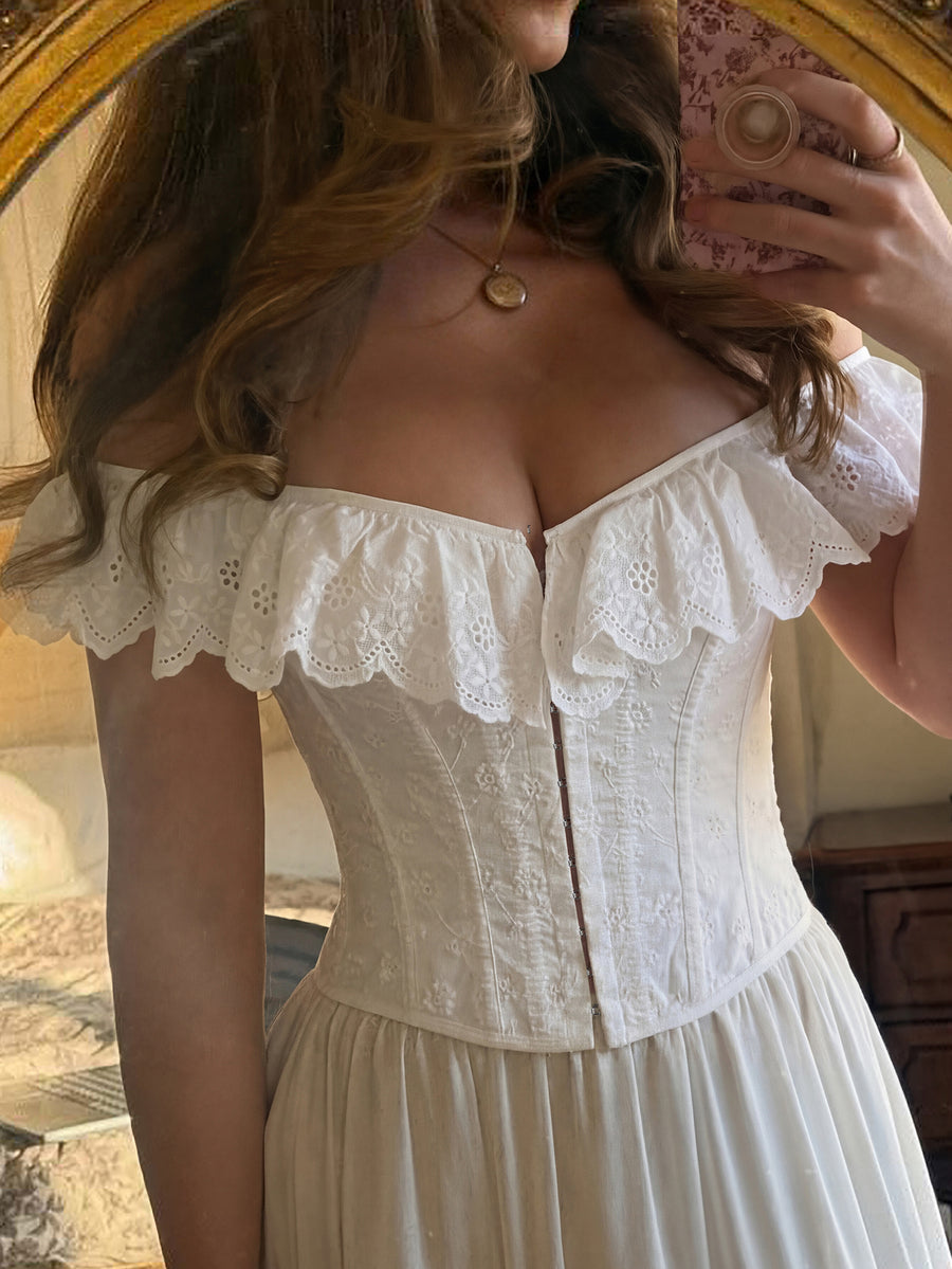 White sleeveless boned corset crop top featuring a square neckline and lace-up back detail.