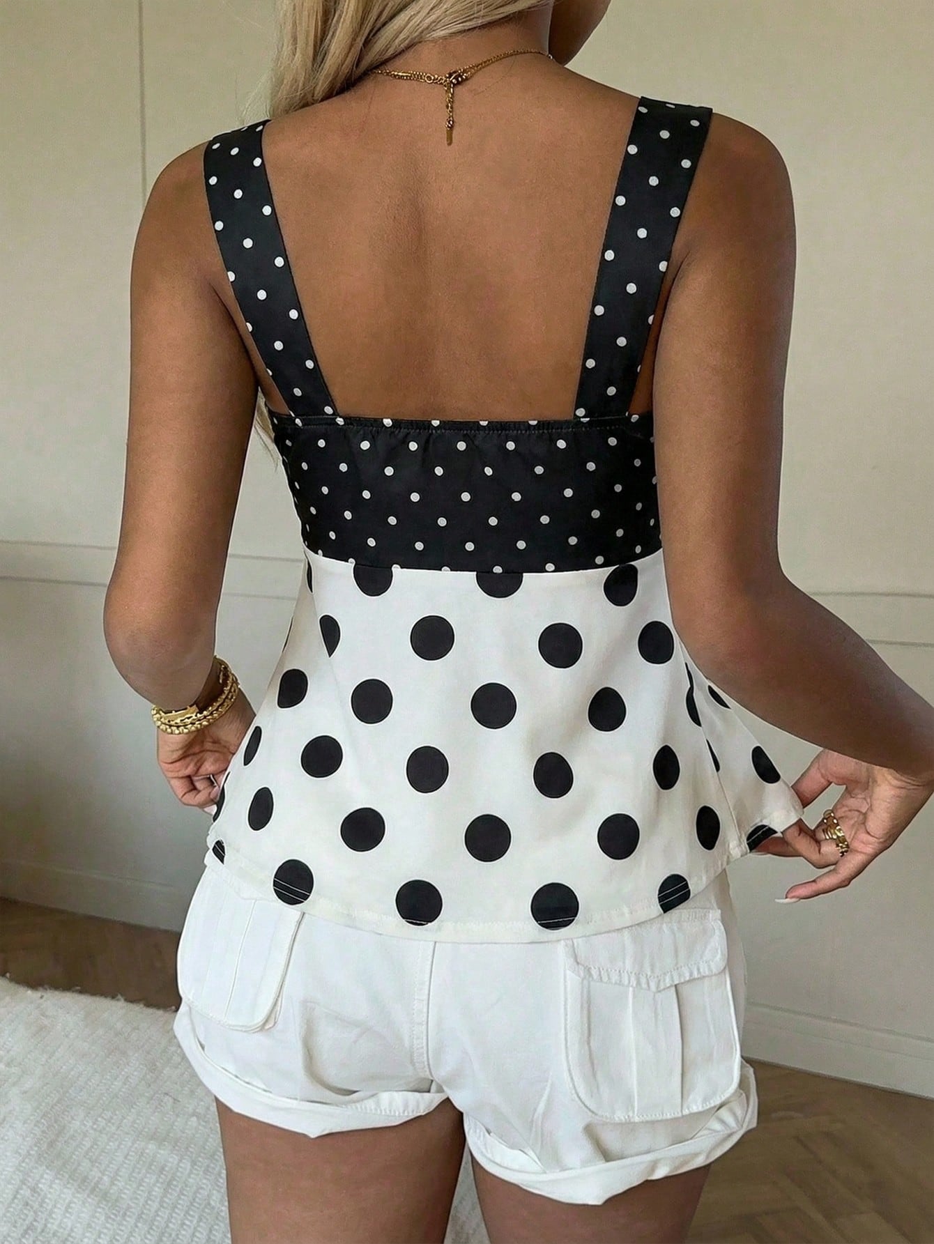 Women's polka dot camisole tank top with strap neckline, bow detail, drawstring style, slim fit, and asymmetrical hem