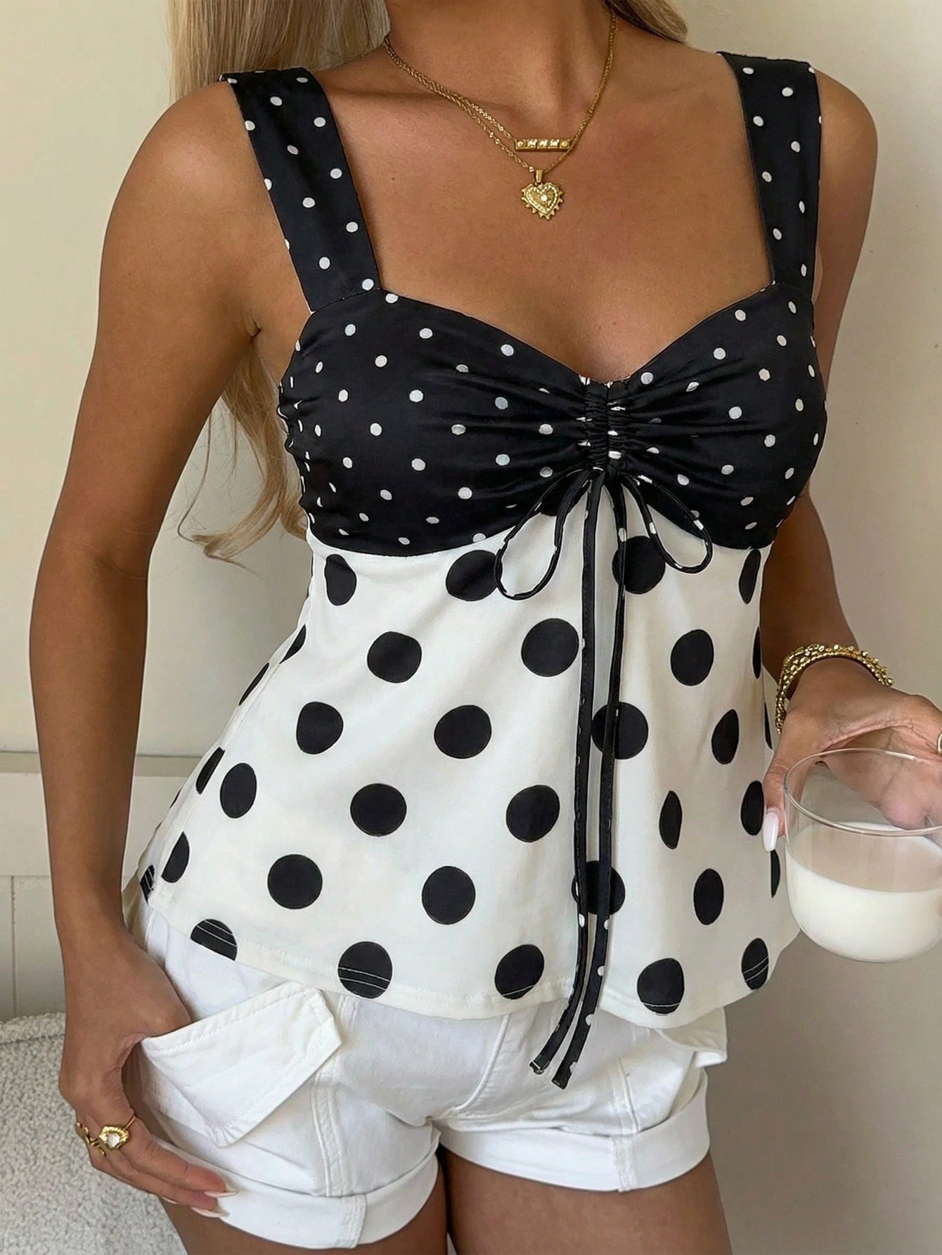 Women's polka dot camisole tank top with strap neckline, bow detail, drawstring style, slim fit, and asymmetrical hem