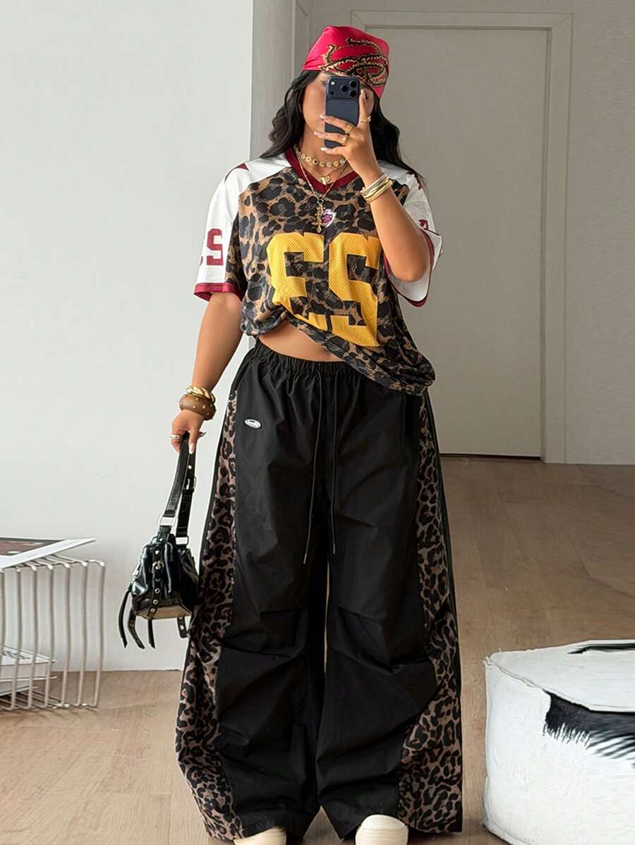 Women's high waist wide leg pants in black featuring leopard print patchwork details and an elastic drawstring waistband.