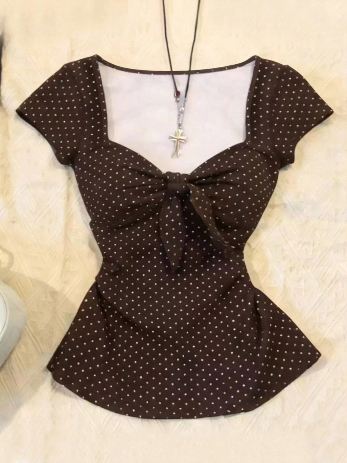 Women's polka dot short sleeve raglan t-shirt with a twist front detail and contrast collar.
