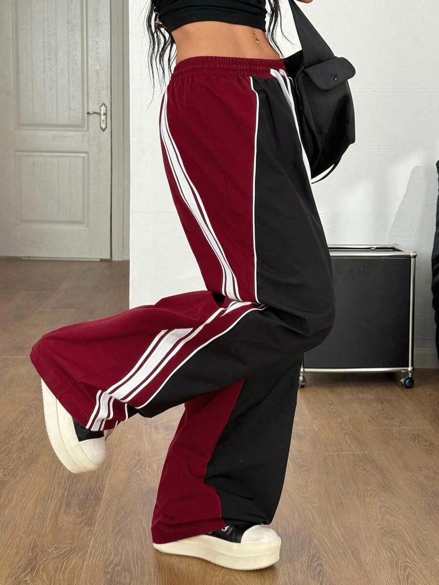 Women's plus size loose straight leg pants featuring a black and white color block design with side stripes and an elastic drawstring waist.