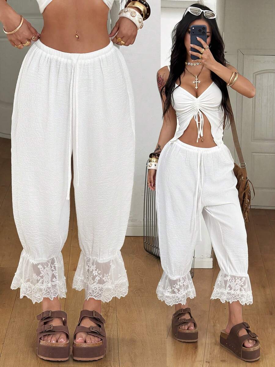 Women's loose-fitting lantern bloomer pants in capri length featuring delicate contrast lace trim and a drawstring waist.