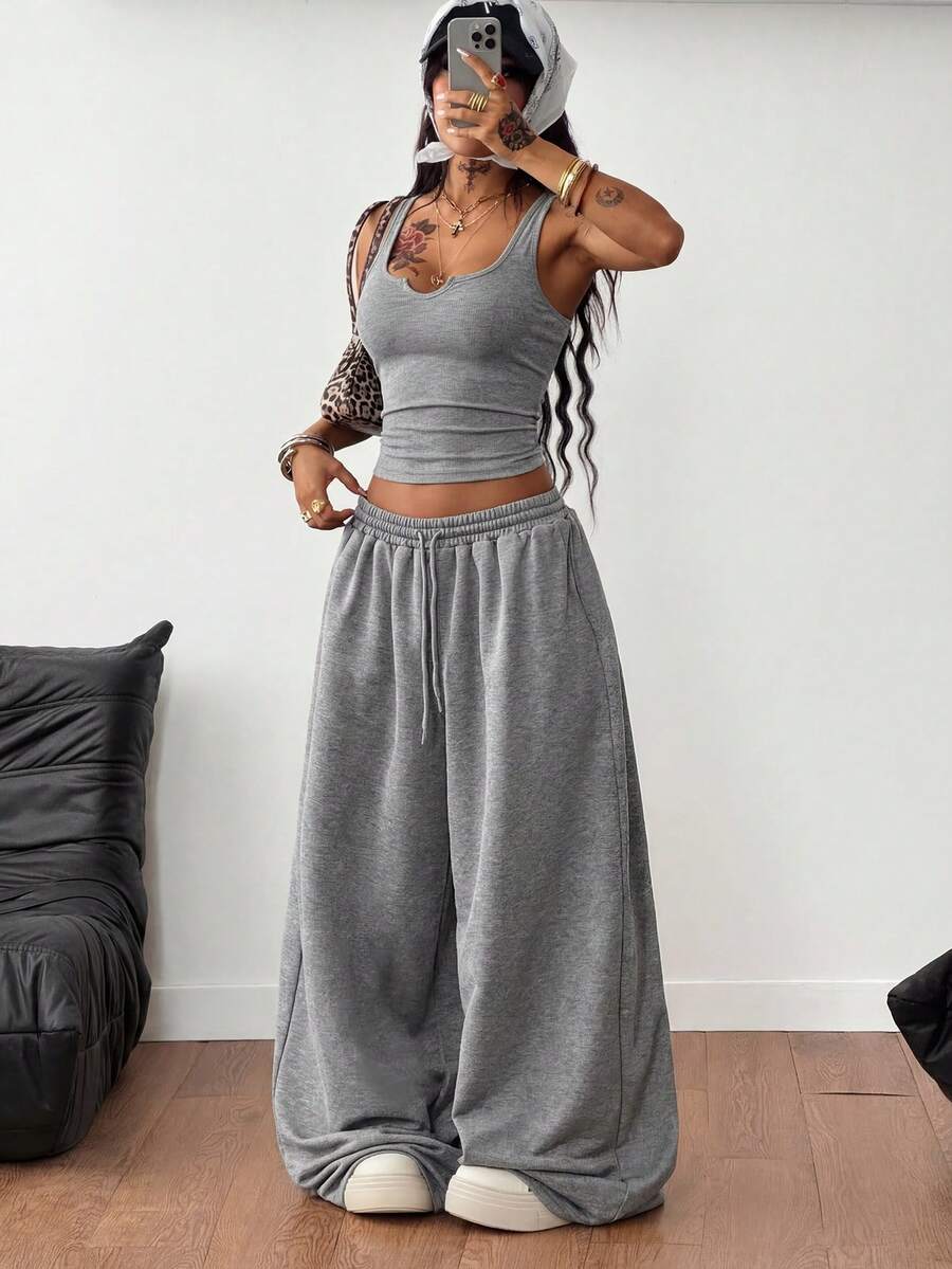 Women's two-piece casual outfit featuring a slim-fit camisole tank top with ruffle trim and button front paired with high-waisted wide leg pants.