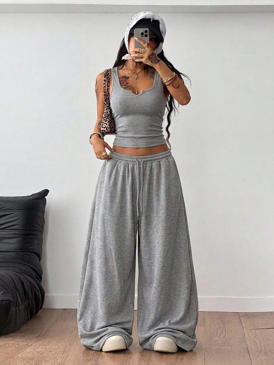 Women's two-piece casual outfit featuring a slim-fit camisole tank top with ruffle trim and button front paired with high-waisted wide leg pants.