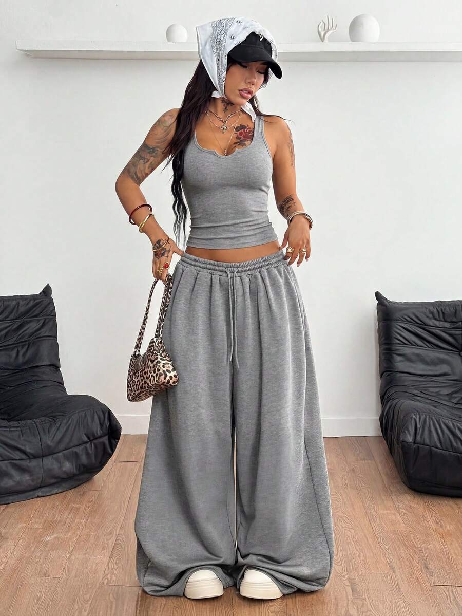 Women's two-piece casual outfit featuring a slim-fit camisole tank top with ruffle trim and button front paired with high-waisted wide leg pants.