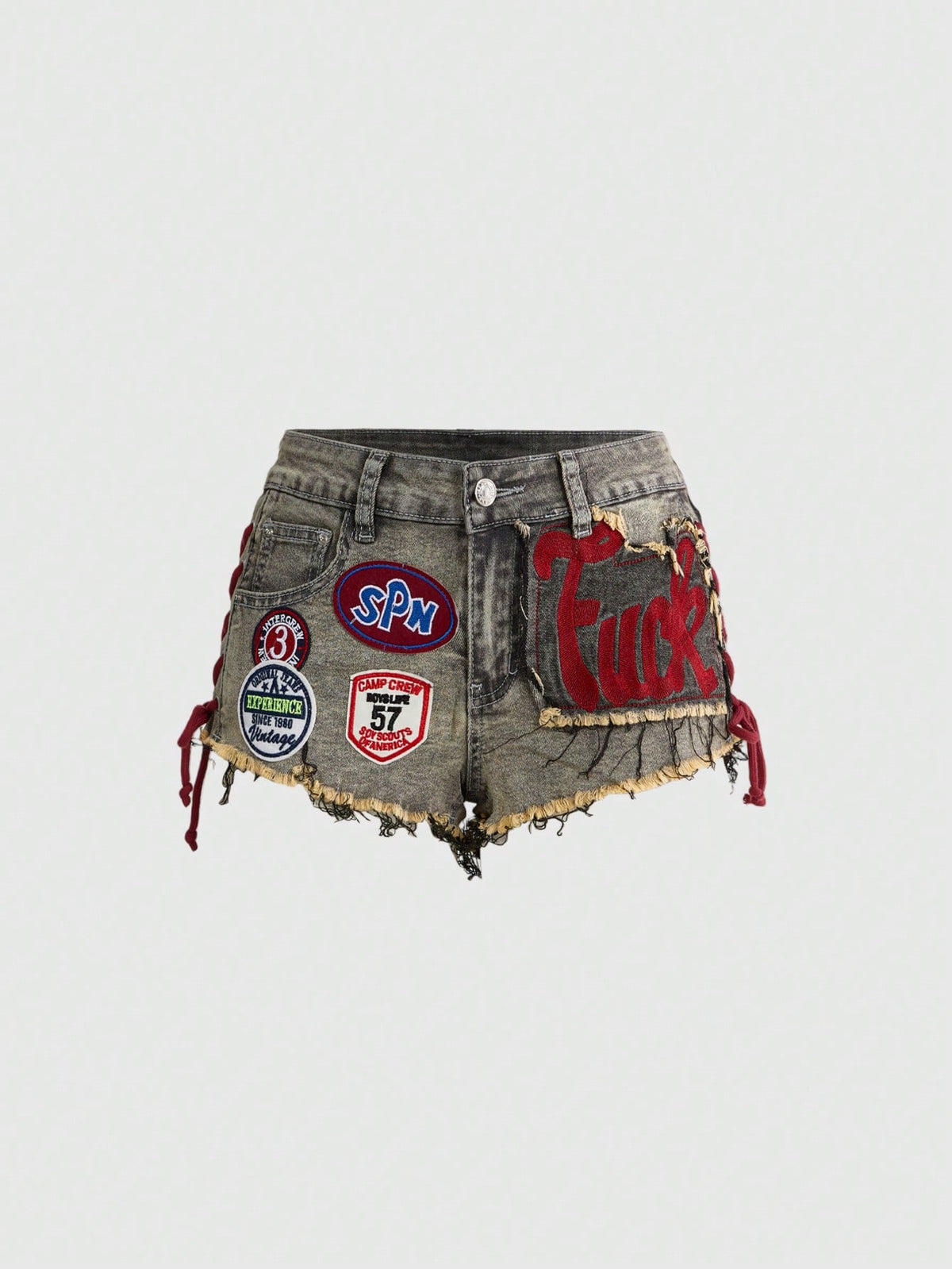 Women's Y2K low waist camo mini skort shorts featuring lace-up knot details, grommet eyelets, graphic lettering pattern, and a zipper fly.