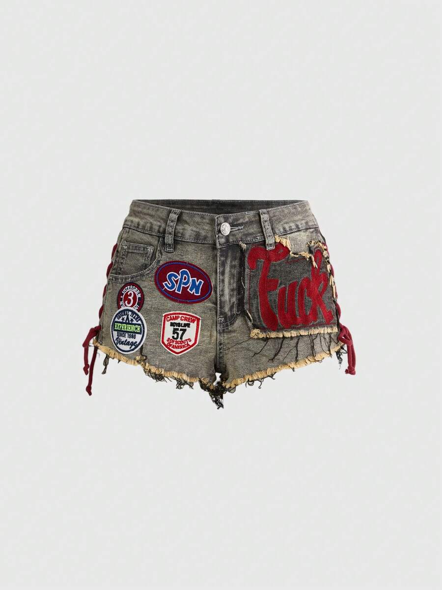 Women's Y2K low waist camo mini skort shorts featuring lace-up knot details, grommet eyelets, graphic lettering pattern, and a zipper fly.