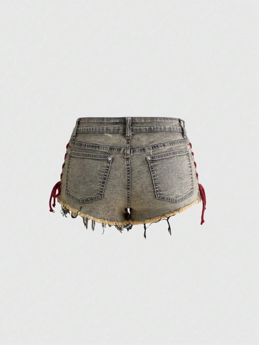 Women's Y2K low waist camo mini skort shorts featuring lace-up knot details, grommet eyelets, graphic lettering pattern, and a zipper fly.